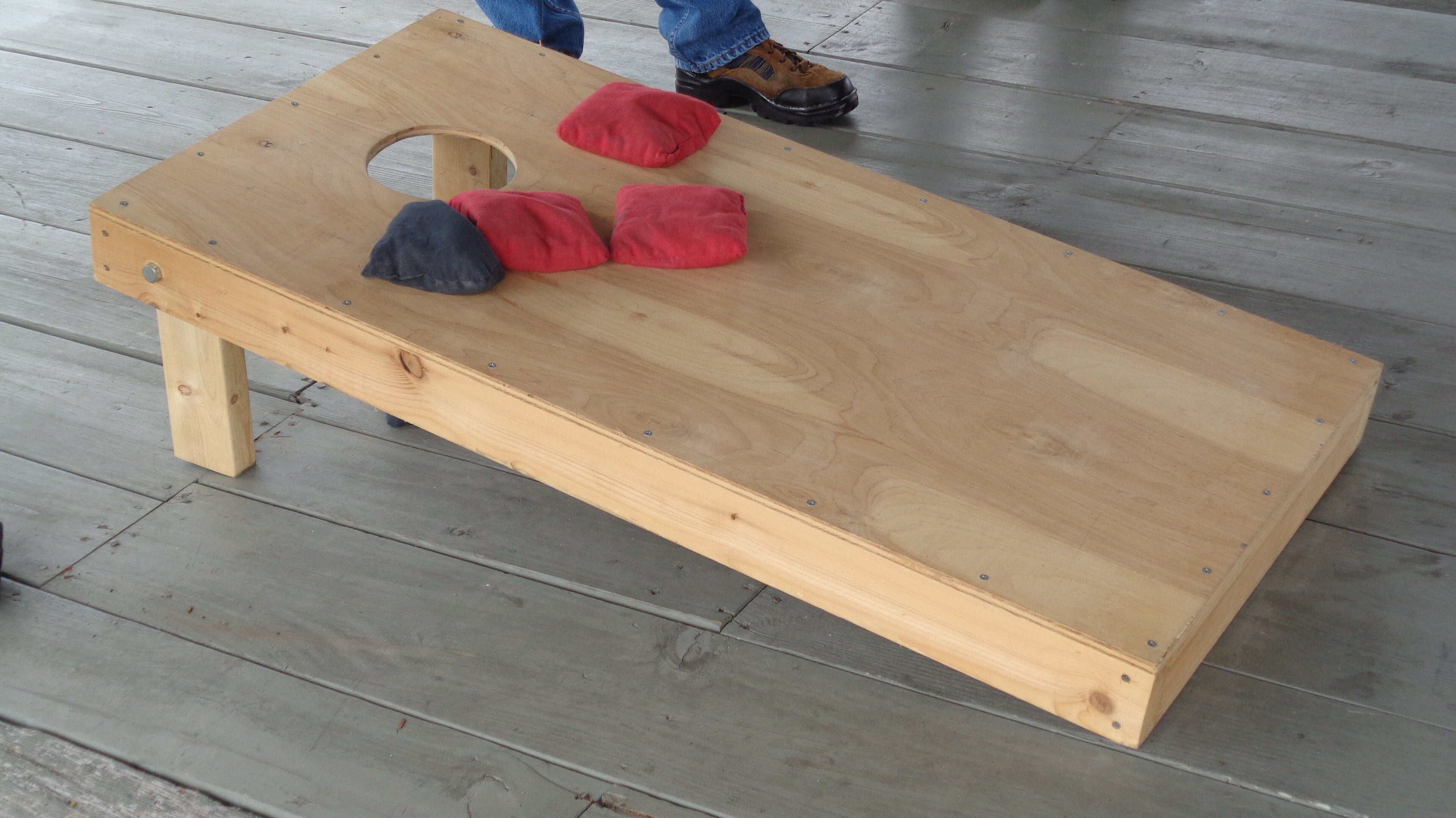 Cornhole boards being played in a backyard, the American comparison point for bocce