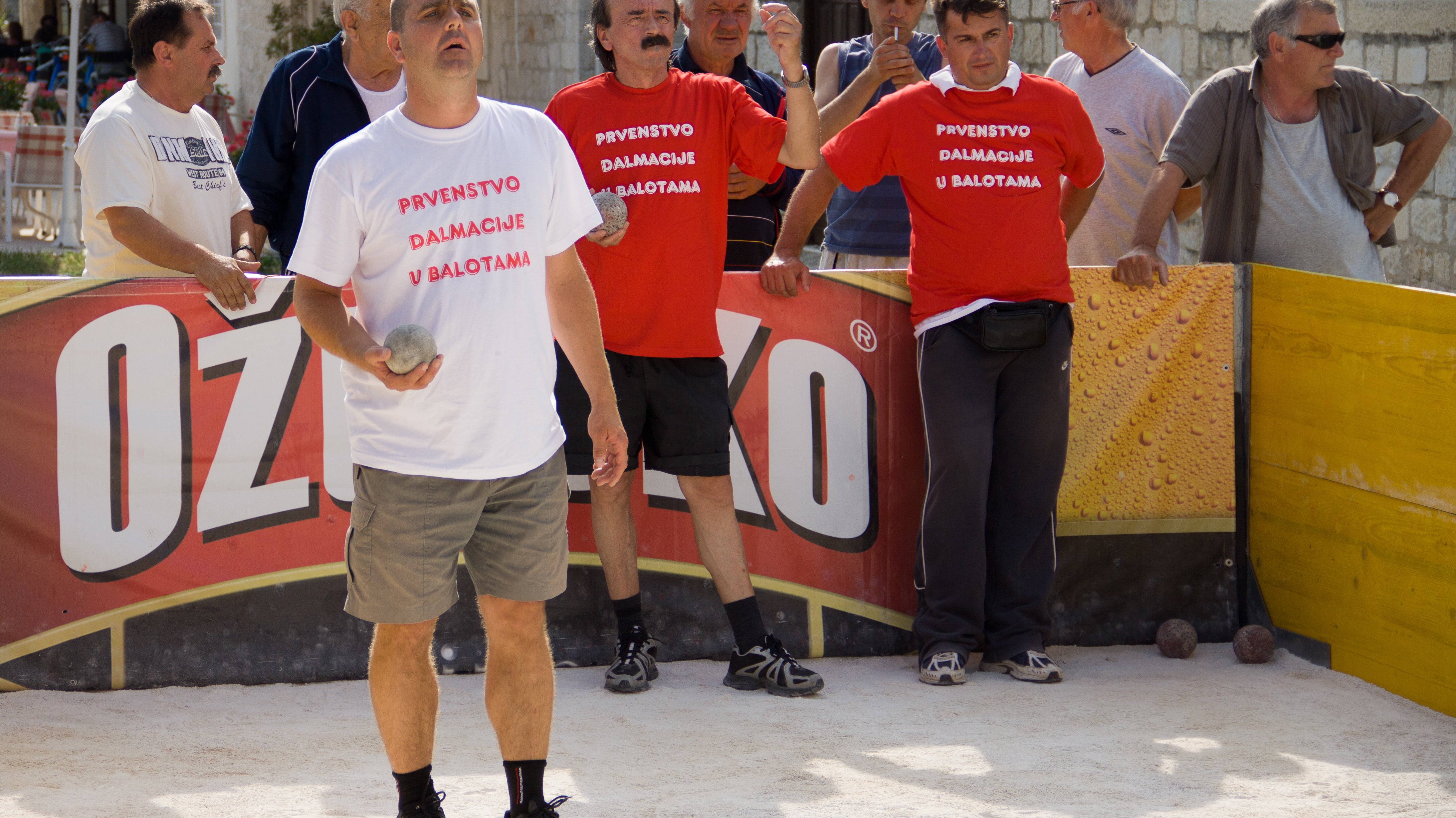 Tournament bocce ball size comparison with players on a court