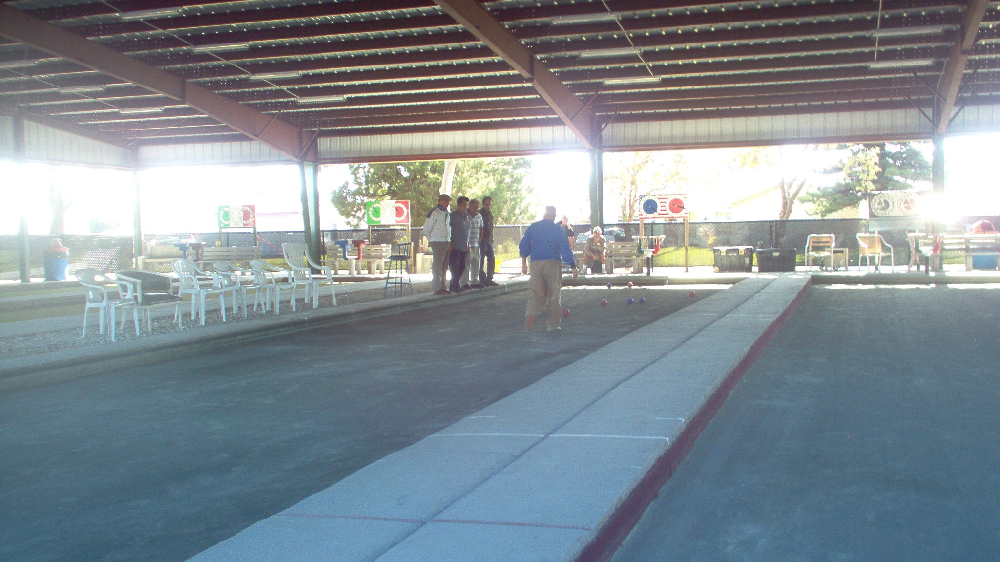 Outdoor bocce match on a clay court in Cape Coral, Florida, showing tournament-style play