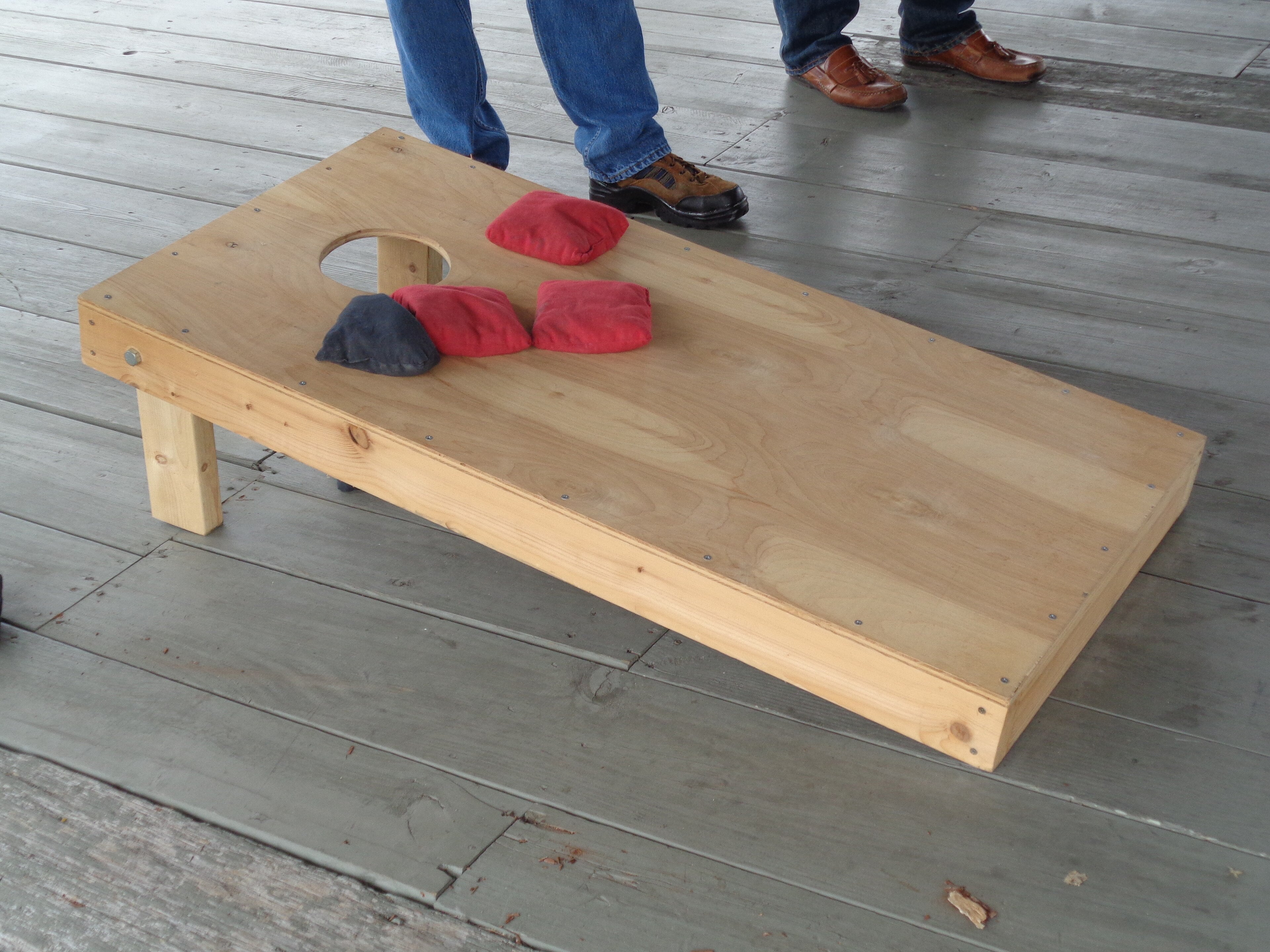 Cornhole boards being played in a backyard, the American comparison point for bocce