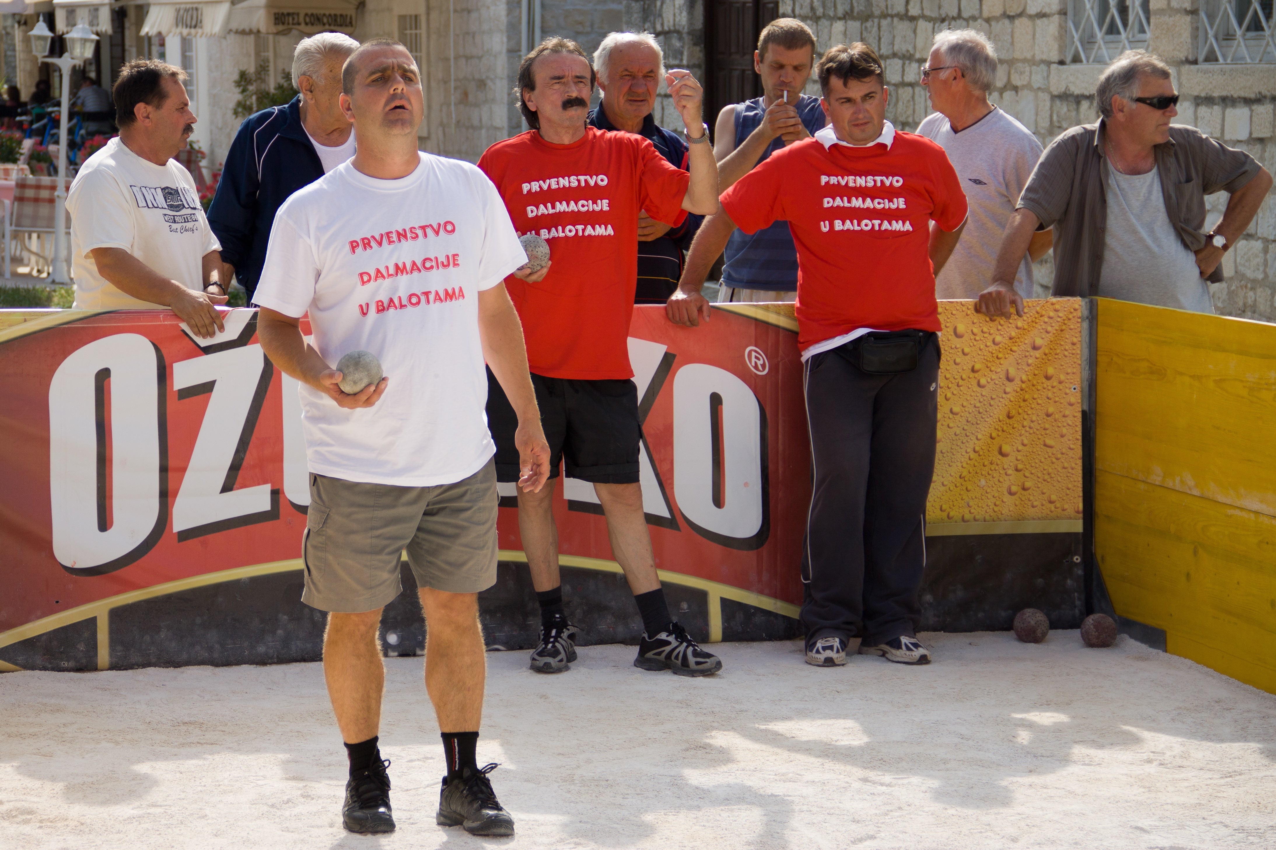 Tournament bocce ball size comparison with players on a court