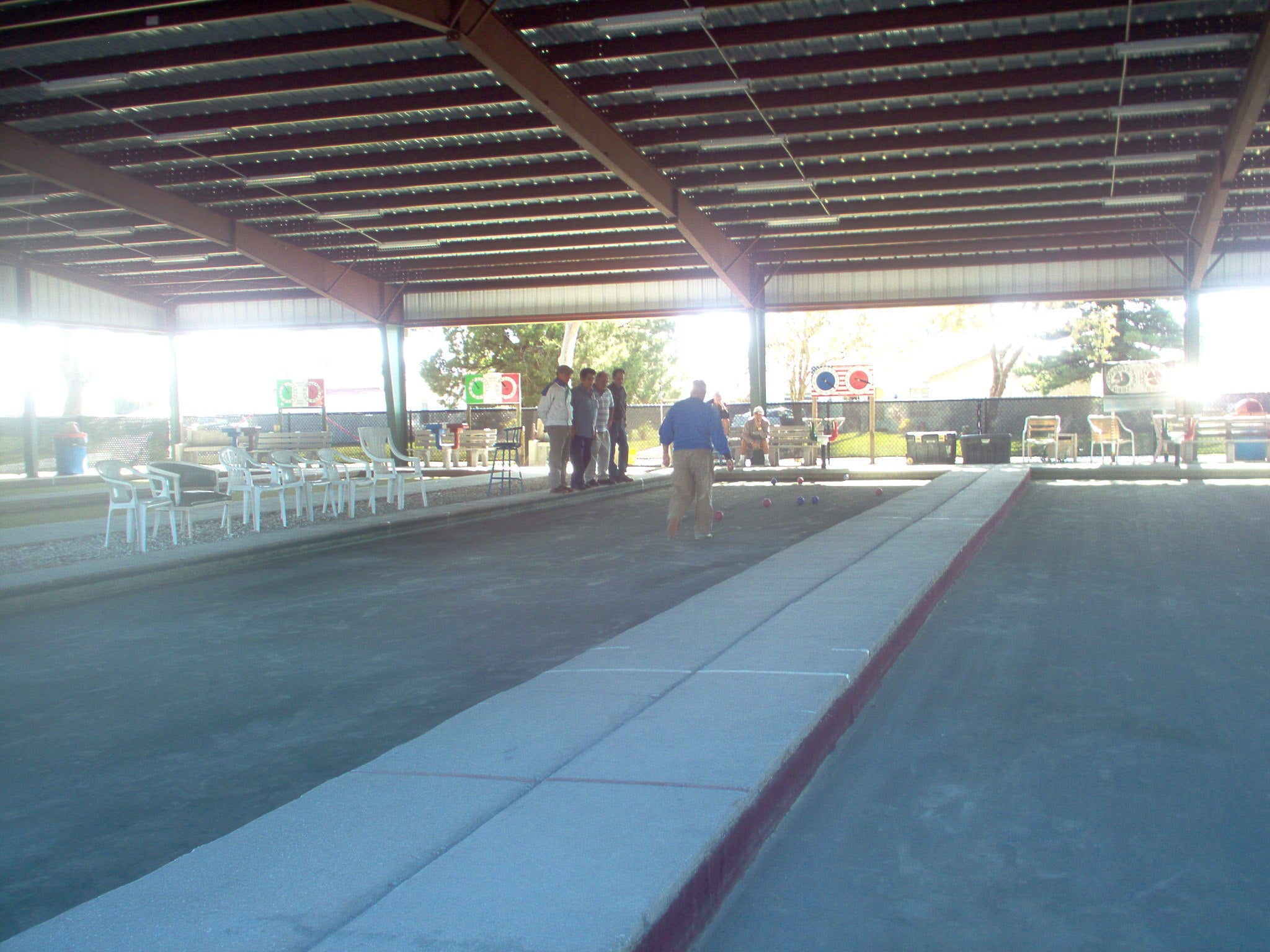 Outdoor bocce match on a clay court in Cape Coral, Florida, showing tournament-style play